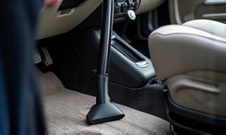 Technician vacuuming the interior of a clean car
